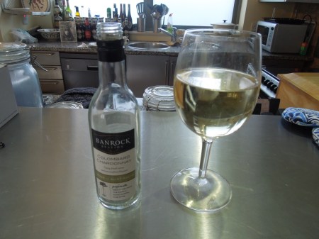 A Small Bottle And Glass Of Wine